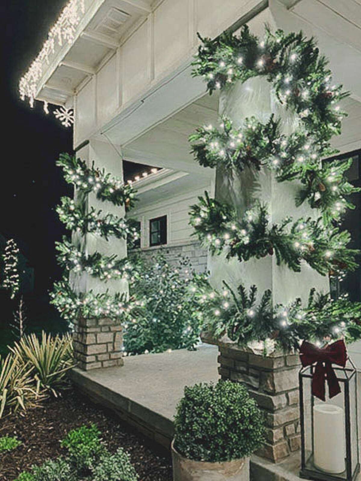 Lit garland and warm white Christmas lights on the front porch of an Omaha house
