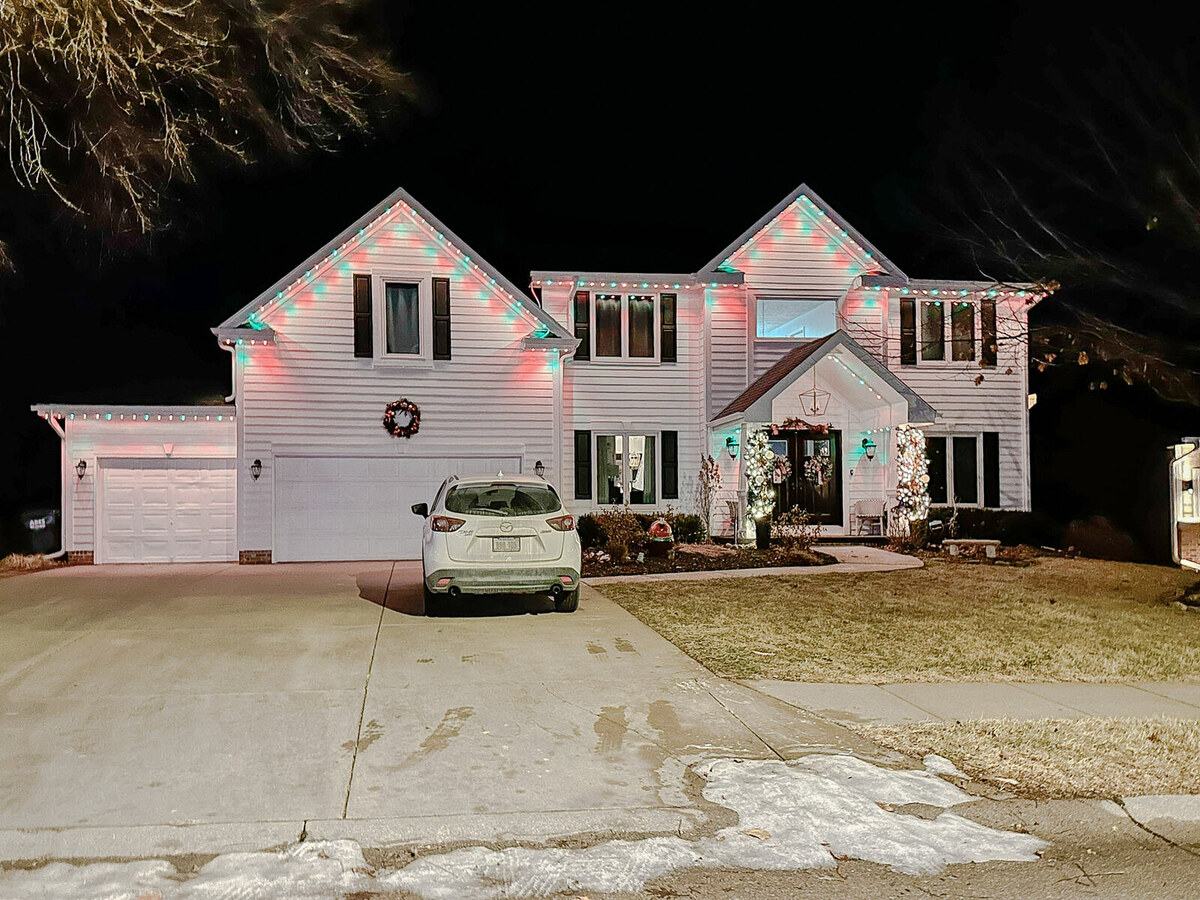 Permanent LED roofline lighting in red and green on an Omaha home for the holiday season