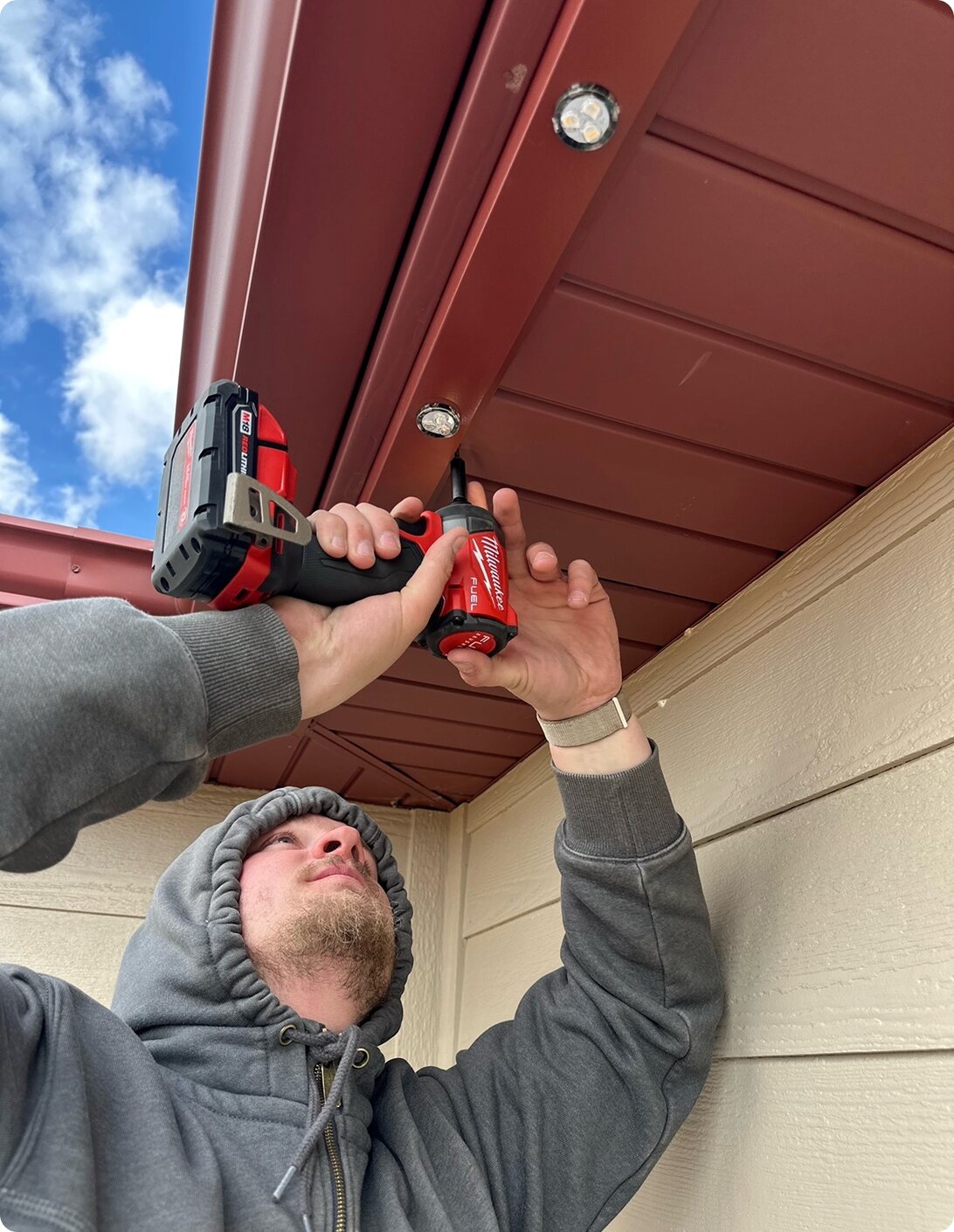 Installer mounting flush Forever Lighting LED modules into a soffit — discreet permanent lighting installation