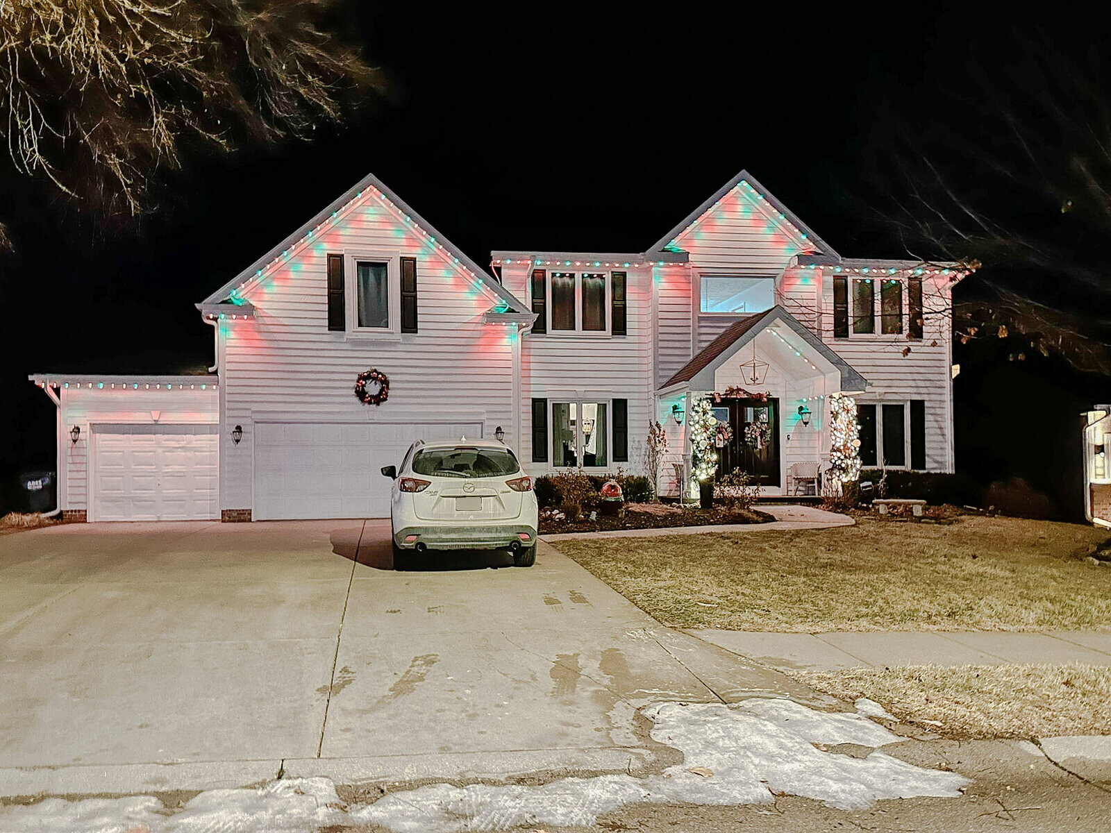 Home with permanent LED lighting installed along the roofline glowing at night